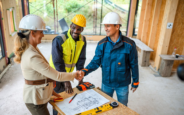 construction and project workers shaking hands and agreeing with construction plans
